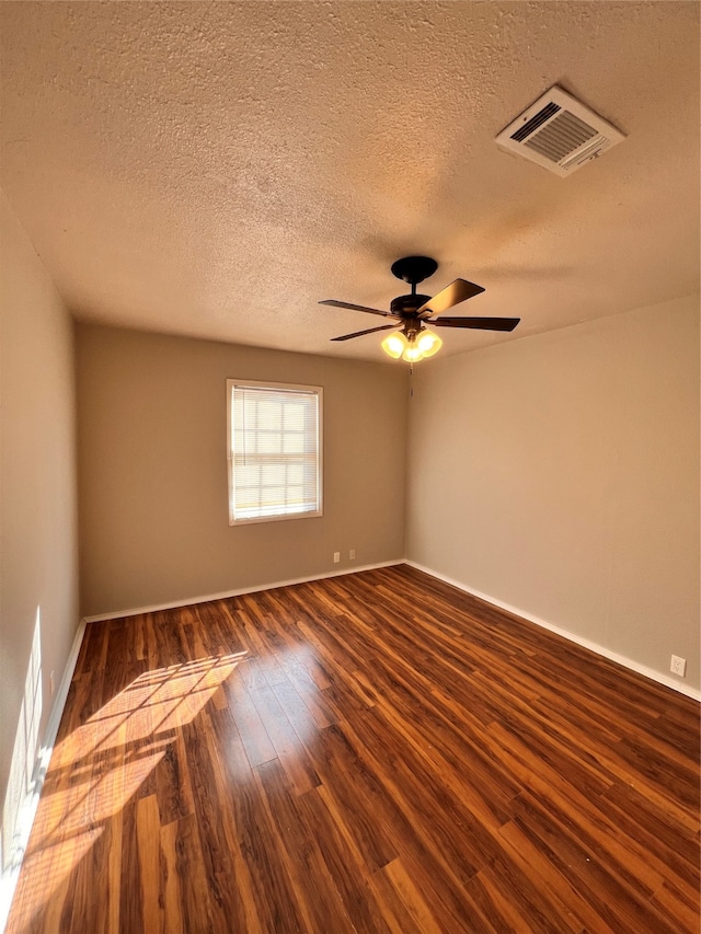 unfurnished room with a textured ceiling, ceiling fan, and dark wood-type flooring