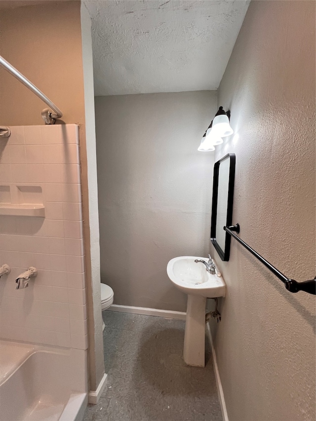 bathroom featuring a textured ceiling, toilet, and concrete floors