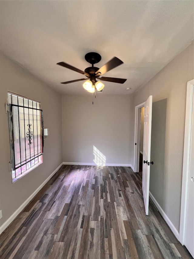 empty room with dark wood-type flooring and ceiling fan