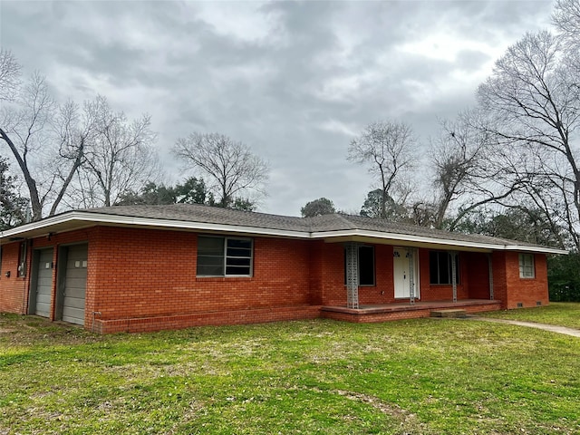 ranch-style house featuring covered porch, a front yard, and a garage