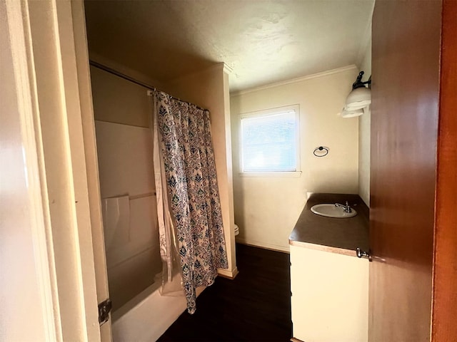 full bathroom featuring toilet, vanity, hardwood / wood-style floors, shower / bath combination with curtain, and ornamental molding