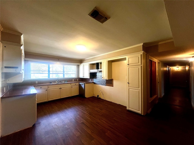 kitchen with crown molding, tasteful backsplash, wall chimney range hood, and dark hardwood / wood-style flooring