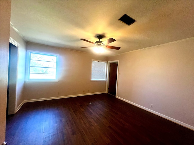 spare room with ceiling fan, dark wood-type flooring, and crown molding