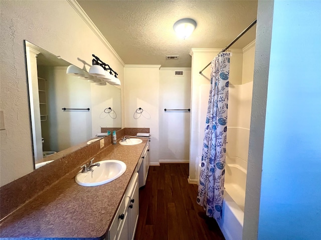 full bathroom with ornamental molding, shower / tub combo with curtain, dual sinks, oversized vanity, and hardwood / wood-style flooring