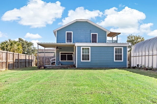 back of house featuring a lawn and ceiling fan