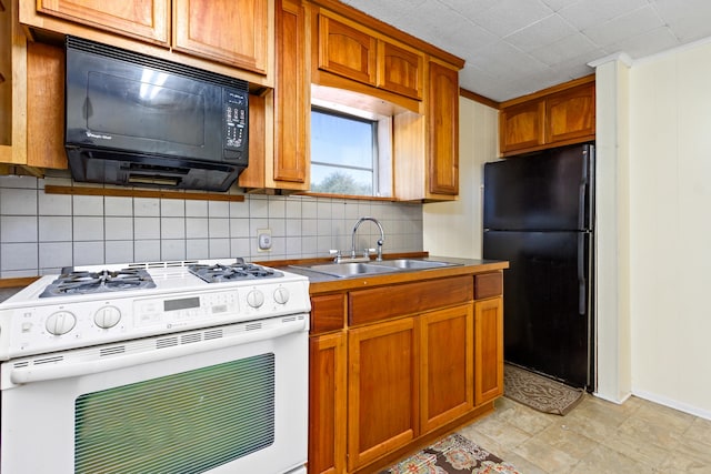 kitchen with sink, light tile floors, crown molding, black appliances, and tasteful backsplash