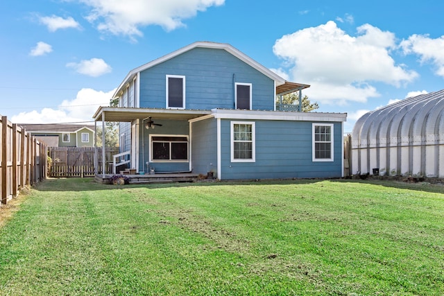 back of property with a lawn and ceiling fan