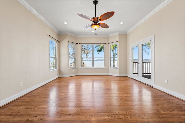 unfurnished room with ceiling fan, crown molding, light hardwood / wood-style floors, and french doors