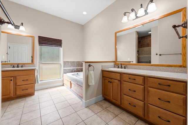 bathroom with tile flooring, vanity, and tiled tub