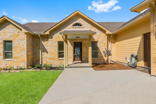 view of exterior entry featuring a lawn