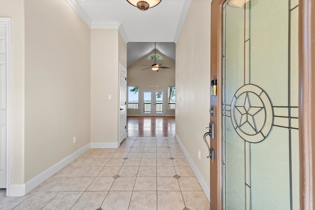 hall featuring crown molding, french doors, vaulted ceiling, and light tile floors