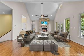 living room with ceiling fan, light hardwood / wood-style flooring, high vaulted ceiling, and plenty of natural light