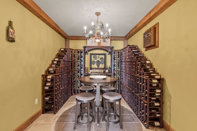 wine room with a wall mounted air conditioner, a notable chandelier, and dark tile flooring