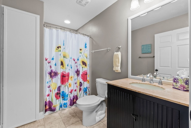 bathroom with toilet, tile floors, and vanity with extensive cabinet space