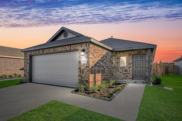 ranch-style home featuring a garage and a lawn