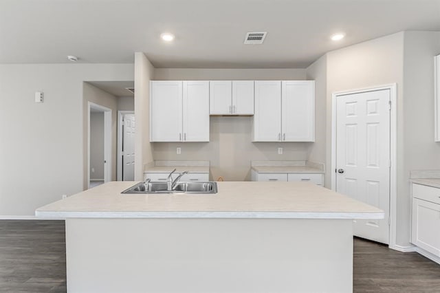 kitchen featuring white cabinets, sink, dark wood-type flooring, and a kitchen island with sink