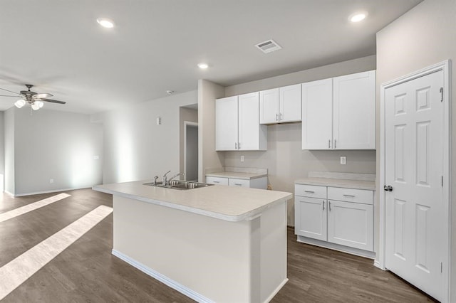 kitchen featuring dark hardwood / wood-style floors, a center island with sink, ceiling fan, white cabinetry, and sink