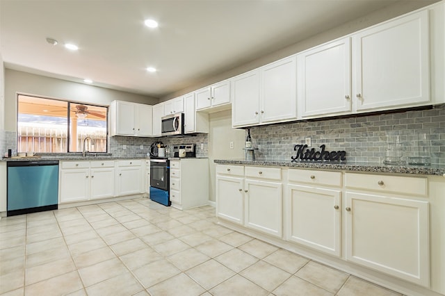 kitchen featuring tasteful backsplash, light tile patterned floors, white cabinets, appliances with stainless steel finishes, and stone countertops