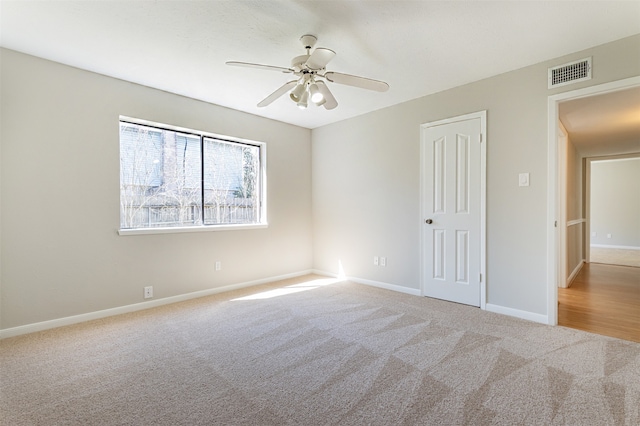 carpeted spare room with ceiling fan