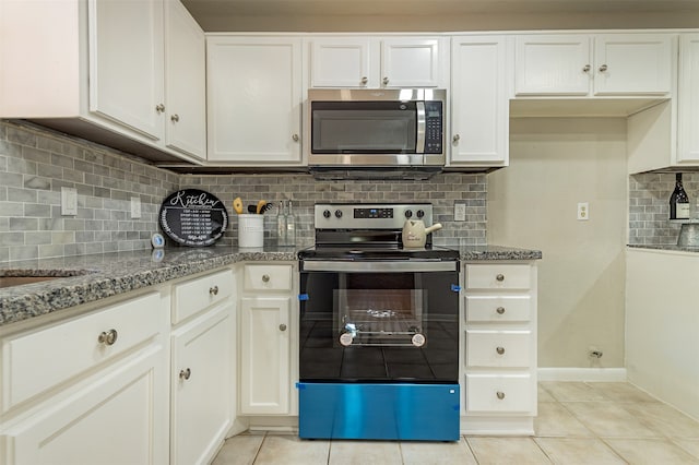 kitchen with tasteful backsplash, stainless steel appliances, white cabinets, stone countertops, and light tile patterned flooring