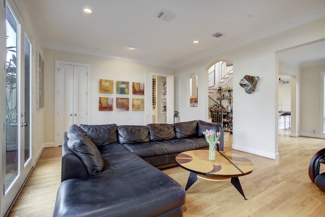 living room with french doors, light hardwood / wood-style floors, and crown molding