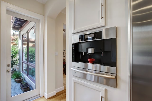 kitchen with white cabinets, light hardwood / wood-style flooring, and stainless steel appliances