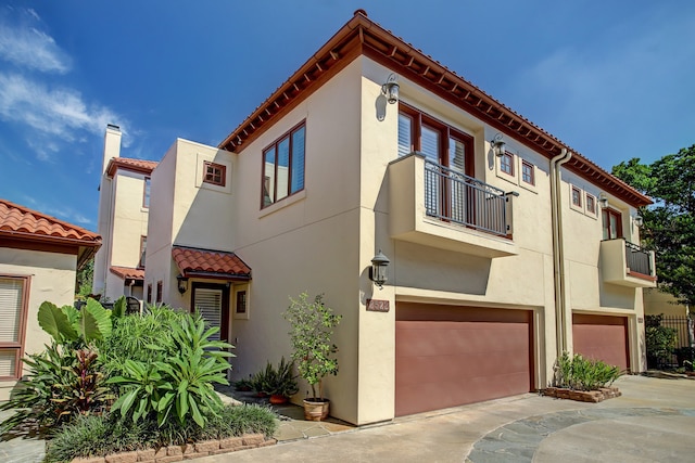 view of front of home with a garage and a balcony