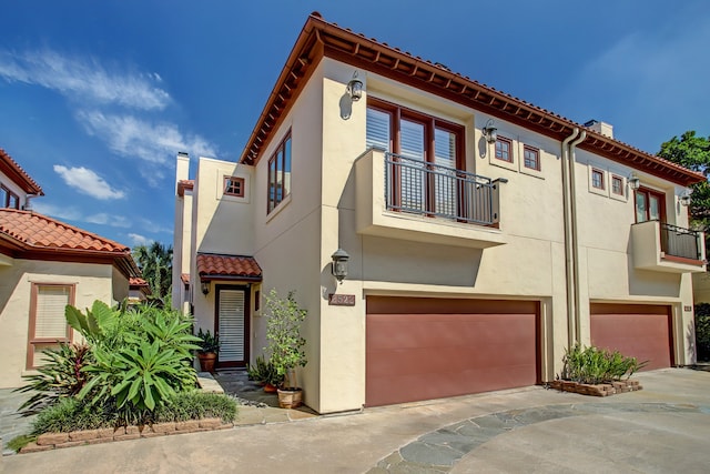 view of front facade featuring a garage and a balcony