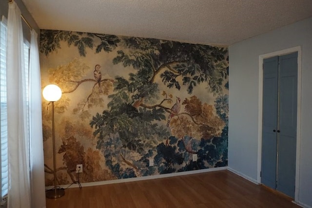 spare room with dark hardwood / wood-style flooring and a textured ceiling