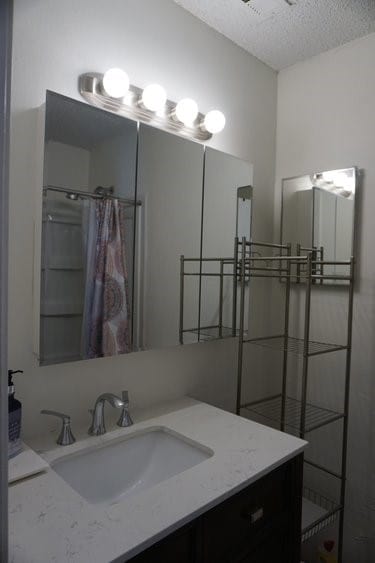 bathroom featuring a textured ceiling and vanity