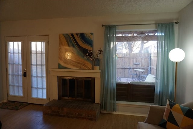 living room with dark hardwood / wood-style floors, a textured ceiling, and french doors