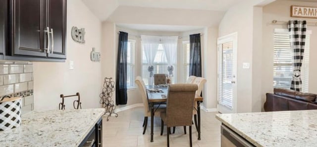 tiled dining area with vaulted ceiling and plenty of natural light