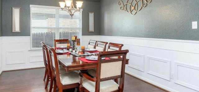 dining area with a chandelier and dark wood-type flooring