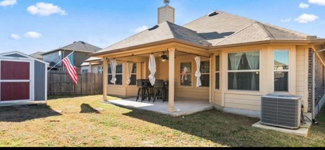 back of house with a lawn, central air condition unit, a storage shed, and a patio