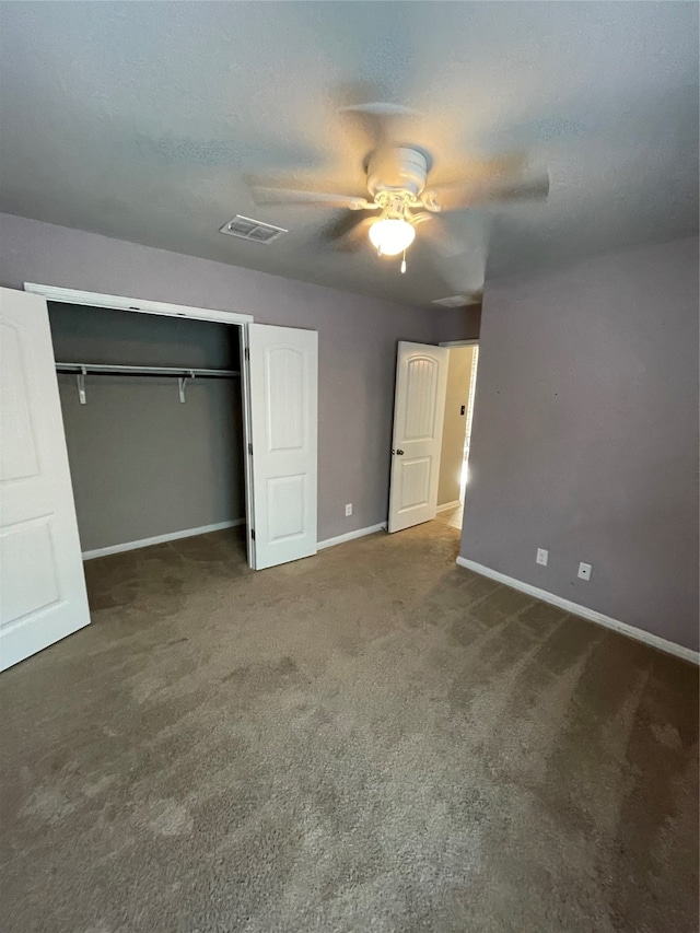 unfurnished bedroom with a closet, ceiling fan, and dark carpet