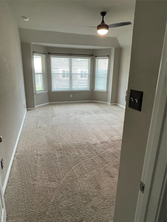 spare room with ceiling fan and carpet