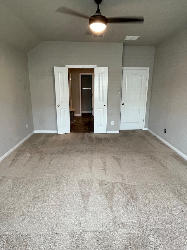 unfurnished bedroom featuring vaulted ceiling, ceiling fan, and carpet floors