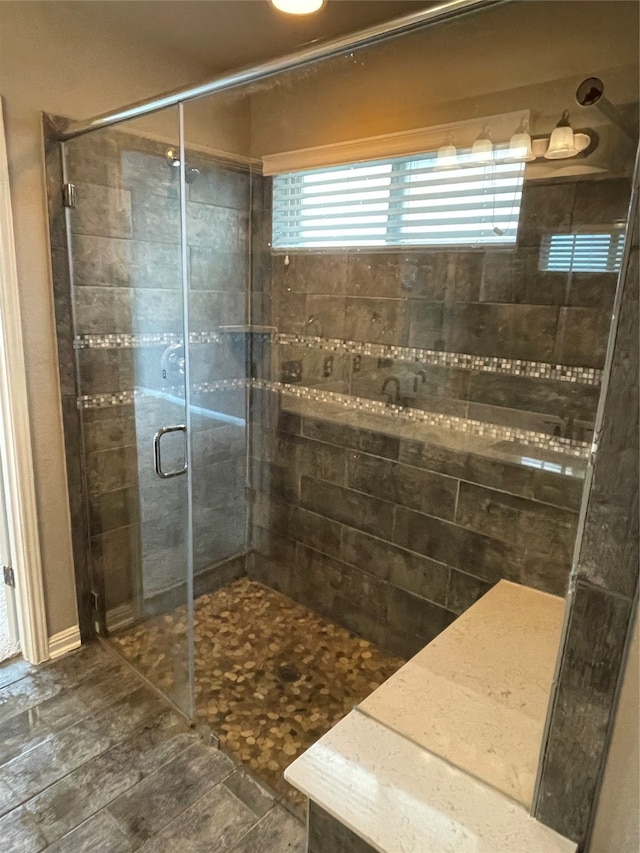 bathroom featuring a shower with shower door and tile floors