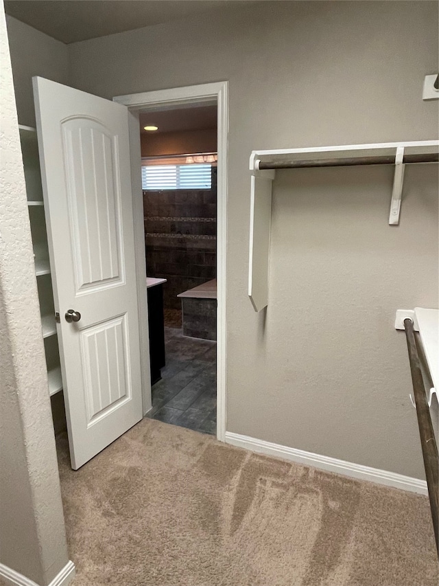 walk in closet featuring dark colored carpet