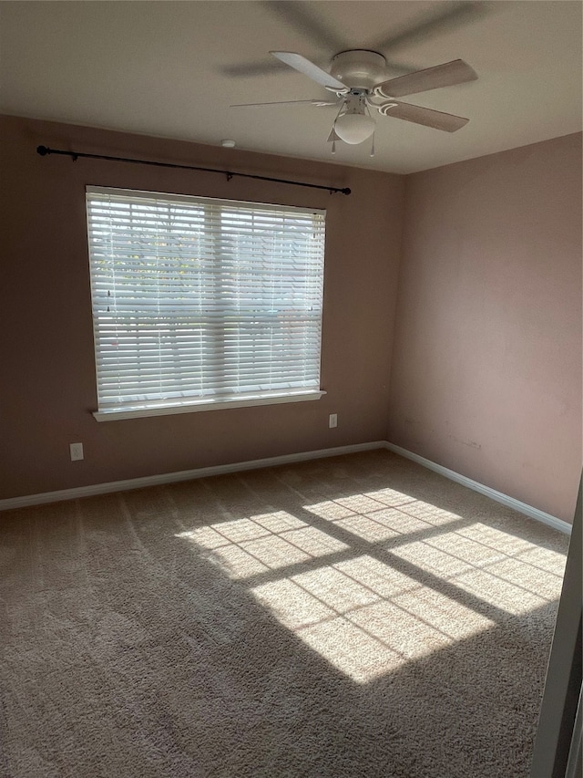 carpeted spare room featuring ceiling fan