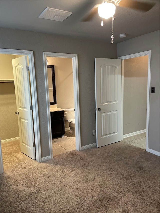 unfurnished bedroom featuring carpet flooring, connected bathroom, and ceiling fan