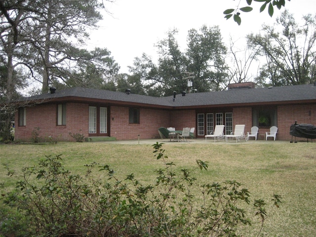 back of property featuring a patio area and a yard