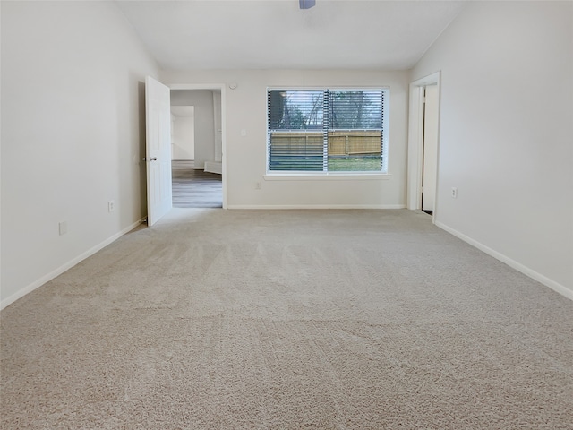 carpeted spare room featuring ceiling fan and lofted ceiling