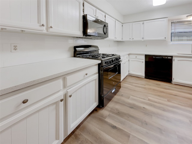 kitchen with black appliances, white cabinetry, and light hardwood / wood-style flooring