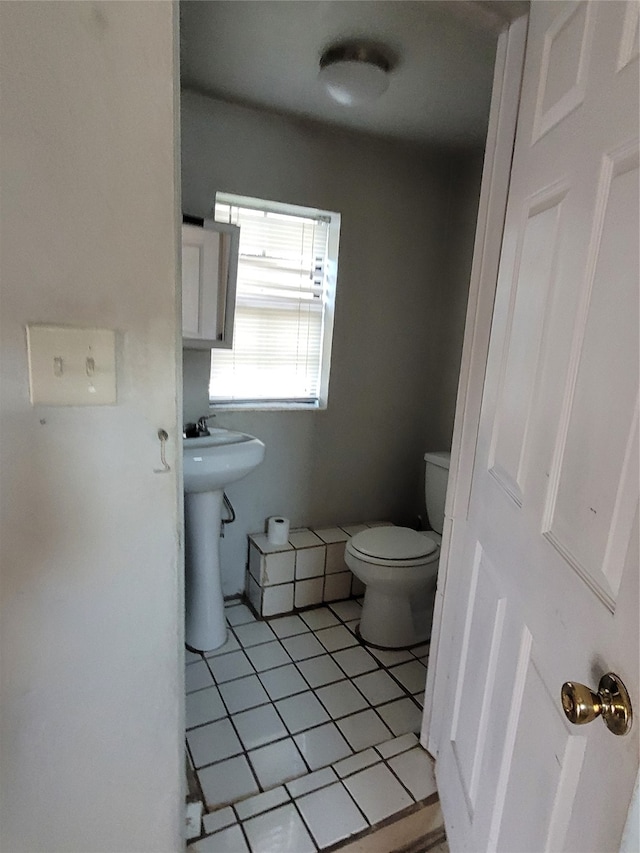 bathroom featuring tile floors and toilet