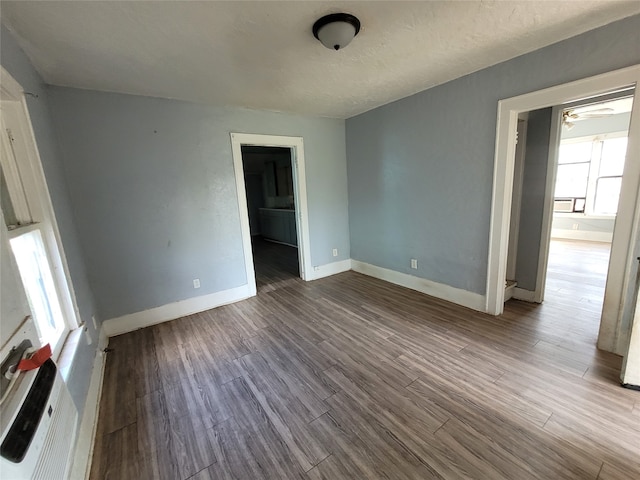 unfurnished room with ceiling fan and dark hardwood / wood-style flooring