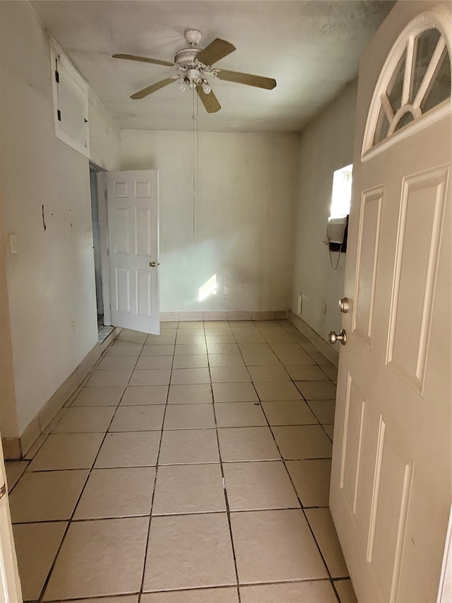 unfurnished room with ceiling fan and light tile flooring