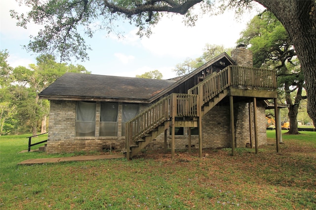 rear view of house featuring a deck and a lawn