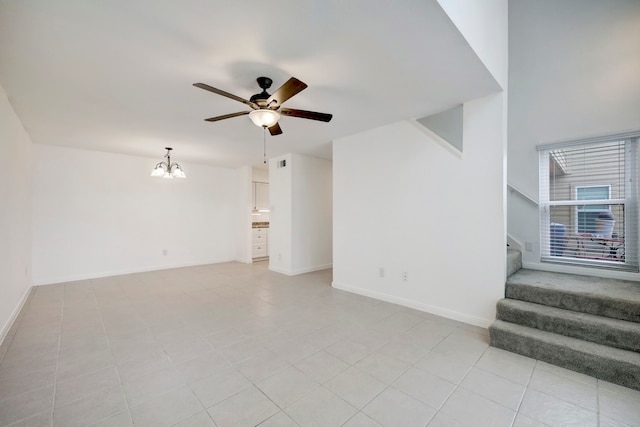 unfurnished living room with ceiling fan with notable chandelier and light tile floors