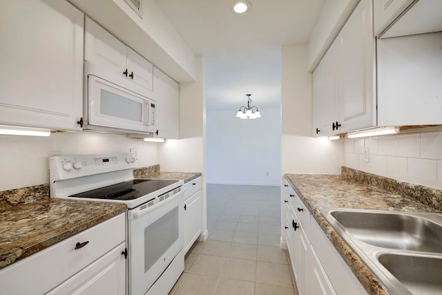 kitchen with an inviting chandelier, white appliances, backsplash, and white cabinets